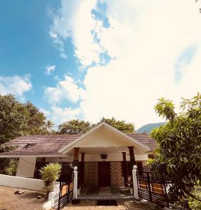 a house with a fence in front of it at Green and Green in Vagamon