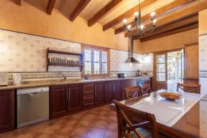 een grote keuken met houten kasten en een tafel bij Villa Cas Mestre in Selva