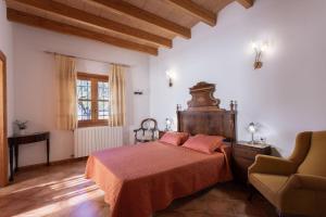 een slaapkamer met een bed en een stoel bij Villa Cas Mestre in Selva +26 foto's