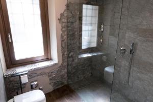 a bathroom with a shower and a toilet and a window at Casa Sofia in Aosta +15 photos