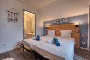 Un dormitorio con una gran cama blanca con almohadas azules. en Ma maison à Disneyland Paris, en Magny-le-Hongre