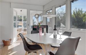 a dining room with a table and chairs and windows at Holiday Home Kalleholled Gudhjem Denm in Gudhjem