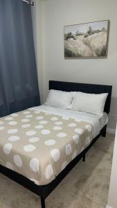 a bed in a bedroom with a black frame at Serene Queen Room Shared Unit in Mississauga