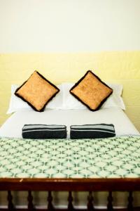 a bed with two pillows on top of it at JayBee's Homestead in Varkala