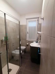 a bathroom with a toilet and a sink and a shower at Appartamento Delfino Blu in Porto Torres