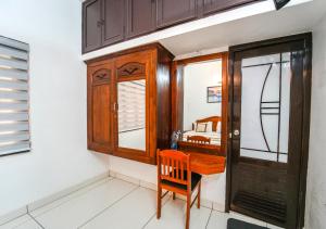 a room with a wooden desk and a bedroom at Pop Tavern Kovalam Beach Villa by VOYE HOMES in Kovalam
