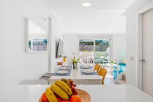 a kitchen and dining room with bananas and oranges on a table at MEDANO4YOU Lego House in El Médano +34 photos
