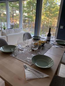 a table with plates and glasses and a bottle of wine at County House - Ingarö in Ingarö