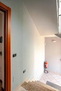 a room with a white wall with a red fire extinguisher at A Home away From Home By Alex in Busto Arsizio