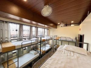 a room with three bunk beds and a window at Ananya Dorms in Hospet