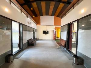 a room with a hallway with a couch and a tv at Ananya Dorms in Hospet +45 photos