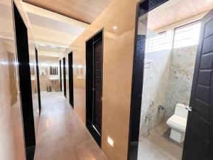 a bathroom with a walk in shower and a toilet at Ananya Dorms in Hospet