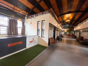 a lobby with a reception desk and chairs in a building at Ananya Dorms in Hospet