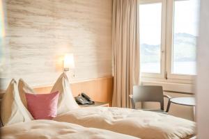 una camera d'albergo con un letto e una finestra di Seeblick Höhenhotel a Emmetten