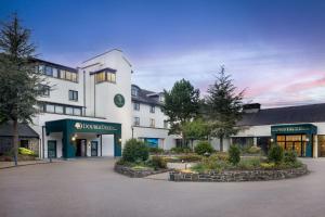 坦普尔帕特里克Doubletree by Hilton Belfast Templepatrick的一座带有停车场的白色大楼