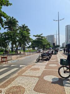 une rue avec des motos garées sur le bord de la route dans l'établissement Loft em prédio em frente à praia, à Santos