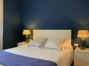 a bedroom with a large bed with two lamps on tables at Villa Truvi in Cala Galdana