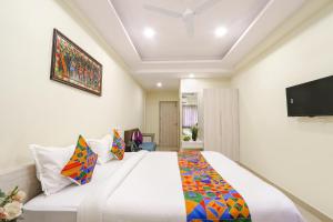 a bedroom with a large bed and a flat screen tv at FabHotel Metro - Nr Secunderabad Railway Station in Hyderabad