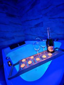 a bottle of wine and glasses on a tray in a bath tub at Centrum jacuzzi prywatny parking klimatyzacja 1 in Radom