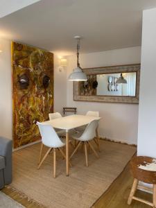 une salle à manger avec une table et des chaises blanches dans l'établissement T1 Valbom Cascais, à Cascais