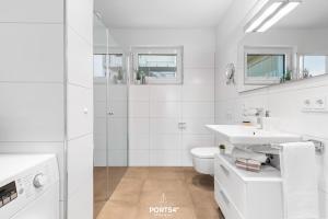 a white bathroom with a toilet and a sink at Ferienwohnung Zuhause am Meer Olpenitz in Olpenitz