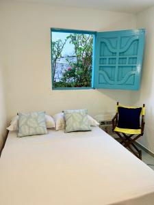 a bedroom with a large white bed with a window at CASA JASMIM, vila florescer, centro histórico!! in Piranhas +18 photos