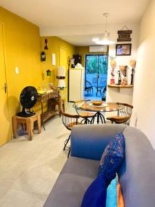 a living room with a blue couch and a table at CASA JASMIM, vila florescer, centro histórico!! in Piranhas