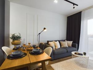 een woonkamer met een tafel en een bank bij Apartments GO Rakowicka by Noclegi Renters in Krakau