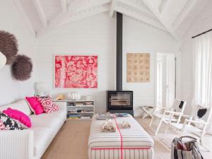 a living room with a white couch and a tv at Cabana com Arte na Comporta in Grândola +34 photos