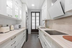 biała kuchnia z białymi szafkami i zlewem w obiekcie Stay U-nique Apartment Sebastián Souvirón w Maladze