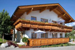 Un gran edificio con sombrillas delante. en Brugger's Ferienwohnungen, en Fulpmes