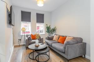 a living room with a couch and a table at Belfast Holiday Home Ormeau Park in Belfast