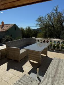 ein Steintisch und eine Bank auf einer Terrasse in der Unterkunft Katia in Grižane + 6 Fotos