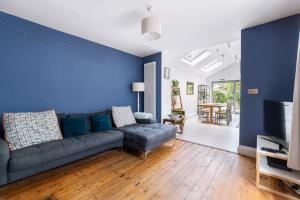 un soggiorno con divano e parete blu di Peaceful 3 bedroom Victorian Cottage a Honiton