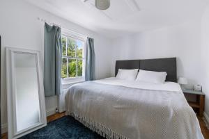a bedroom with a large bed and a window at Quiet Devon Luxury Escape 3-Bed in Honiton