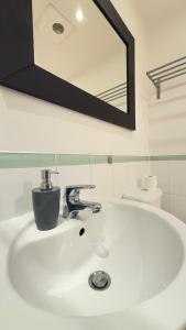 a bathroom sink with a faucet and a mirror at Modern spacious Studio opposite station II in London