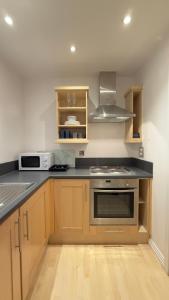 a kitchen with wooden cabinets and a stove top oven at Modern spacious Studio opposite station II in London