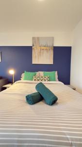 a bedroom with a large bed with a blue wall at Modern spacious Studio opposite station II in London