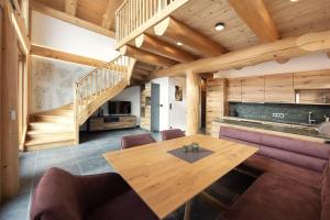 a dining room with a wooden table and a staircase at Chalet Tannenhaus II in Gmünd in Kärnten