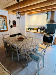 a table and chairs in a kitchen with a table and a table and a kitchen at Barn Gite at La Vieille Grange, with pool in the Dordogne 3 Star in Saint-Privat-des-Prés