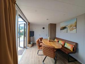 a living room with a table and a couch at Villa Present - Chalet Heinkenszand VP006 in Heinkensand