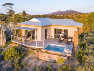 a house with a swimming pool in front of it at Garden Route Game Lodge in Albertinia