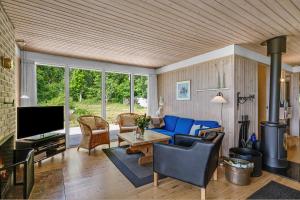 a living room with a blue couch and a table at Nice Home In Knebel With 3 Bedrooms in Knebel