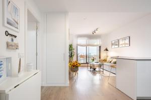 Una cocina blanca y una sala de estar con una mesa. en El Balconcito, en Torre del Mar
