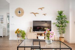sala de estar con mesa de cristal y plantas en El Balconcito, en Torre del Mar