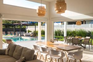 a patio with a table and chairs and a pool at Lagon Paradis - 6 Villas individuelles avec Piscine ou Jacuzzi - Loc Voiture Cabriolet ou SUV in Le Gosier +62 photos