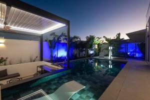 an indoor pool in a house with blue lights at Lagon Paradis - 6 Villas individuelles avec Piscine ou Jacuzzi - Loc Voiture Cabriolet ou SUV in Le Gosier