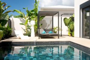 a swimming pool in front of a house at Lagon Paradis - 6 Villas individuelles avec Piscine ou Jacuzzi - Loc Voiture Cabriolet ou SUV in Le Gosier