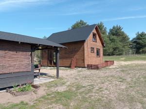 a home with a gambrel roof and a house at Chatka na Wiedźmiej Górce in Kuttlau