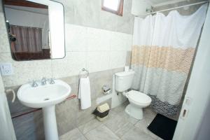 a bathroom with a sink and a toilet and a mirror at Iguazú Green Hotel in Puerto Iguazú +7 photos